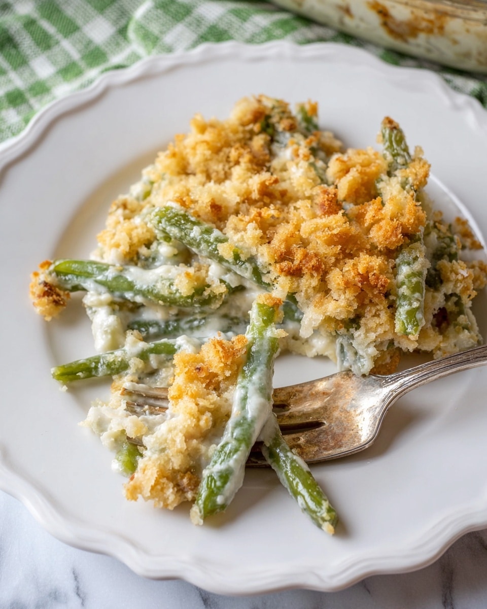 The image shows a creamy green bean casserole served on a white scalloped plate. The dish has two main layers: at the bottom, bright green beans are arranged lengthwise with a thick layer of white creamy sauce covering and filling spaces between them. On top, there is a golden brown crumbly topping that looks crispy and light. A fork holding a small portion of the casserole with all three layers is resting on the plate. The plate sits on a white marbled surface with a green-striped cloth partially visible in the background. Photo taken with an iphone --ar 4:5 --v 7