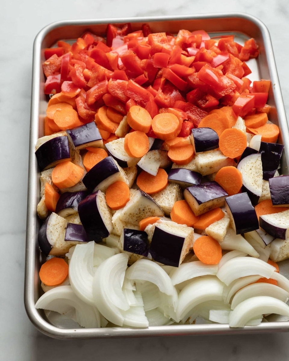 The image shows a metal tray filled with layers of raw chopped vegetables. The bottom layer has white onion slices, arranged in curved strips. Above this are pieces of purple eggplant with a spongy texture and light cream inside, mixed with bright orange carrot slices cut into rounds. On top of this is a layer of small, bright red bell pepper chunks spread evenly across the tray. The tray is placed on a white marbled surface. Photo taken with an iphone --ar 4:5 --v 7