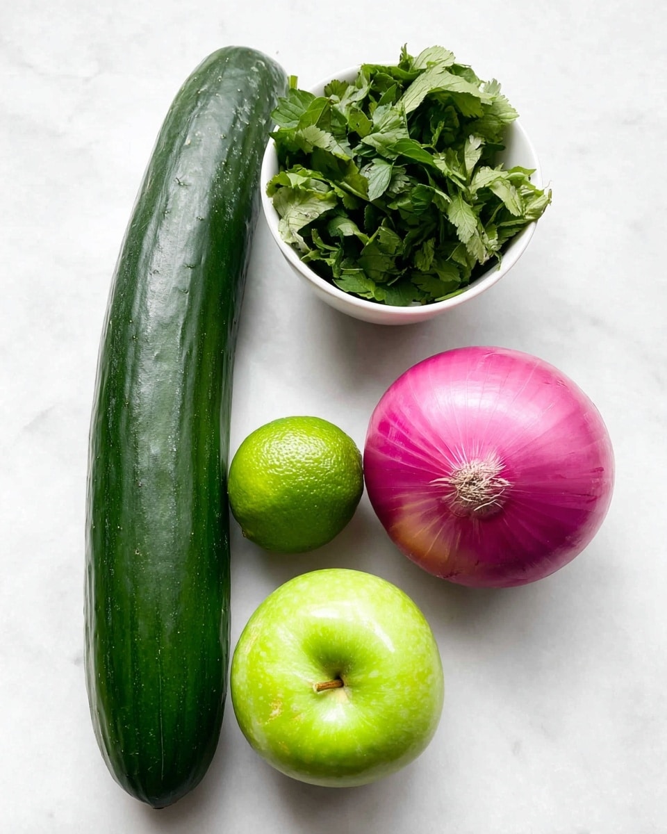 The image shows five fresh ingredients arranged on a white marbled surface: a long, dark green cucumber lying diagonally on the left; a bright pink whole onion with smooth skin placed near the center; a small round lime with a shiny green peel next to the onion; a shiny green apple below the lime; and a white bowl filled with fresh green leafy herbs sitting above the onion and lime. The colors are vibrant and the textures are clear, with natural light creating soft shadows. photo taken with an iphone --ar 4:5 --v 7