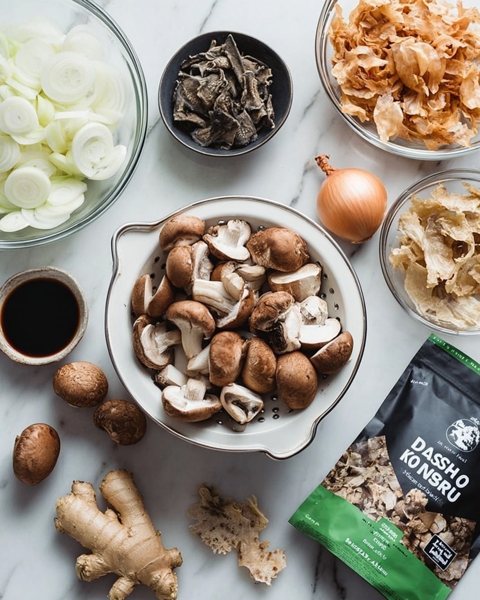 The image shows a top view of various fresh ingredients arranged on a white marbled surface. In the center, there is a white colander filled with halved brown mushrooms, surrounded by whole brown mushrooms scattered around it. To the left, there is a clear glass bowl with thinly sliced white onions and nearby, a small black bowl with dried mushrooms. Above these, a small clear bowl of dark soy sauce is placed next to a whole bulb of garlic. On the right side, there is a clear bowl filled with light brown onion skins, and beside it, a piece of fresh ginger root. In the bottom right corner, a green and black packet labeled
