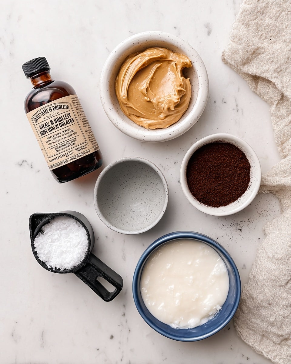 A group of six containers sits on a white marbled surface, arranged neatly. In the top left, there is a dark brown bottle with a label of organic pure bourbon vanilla extract. To its right, a small white bowl holds light tan, smooth creamy peanut butter with slight texture on the surface. Next to it, on the right, another small white bowl is filled with dark brown, fine ground coffee. Below the vanilla bottle, a small gray bowl contains a clear liquid. To its right, below the peanut butter bowl, a blue bowl is filled almost to the top with frothy, light beige almond milk. Finally, on the bottom left, a black measuring cup is filled with solid white coconut oil with a rough texture. A beige cloth is partly visible in the top right corner. Photo taken with an iphone --ar 4:5 --v 7