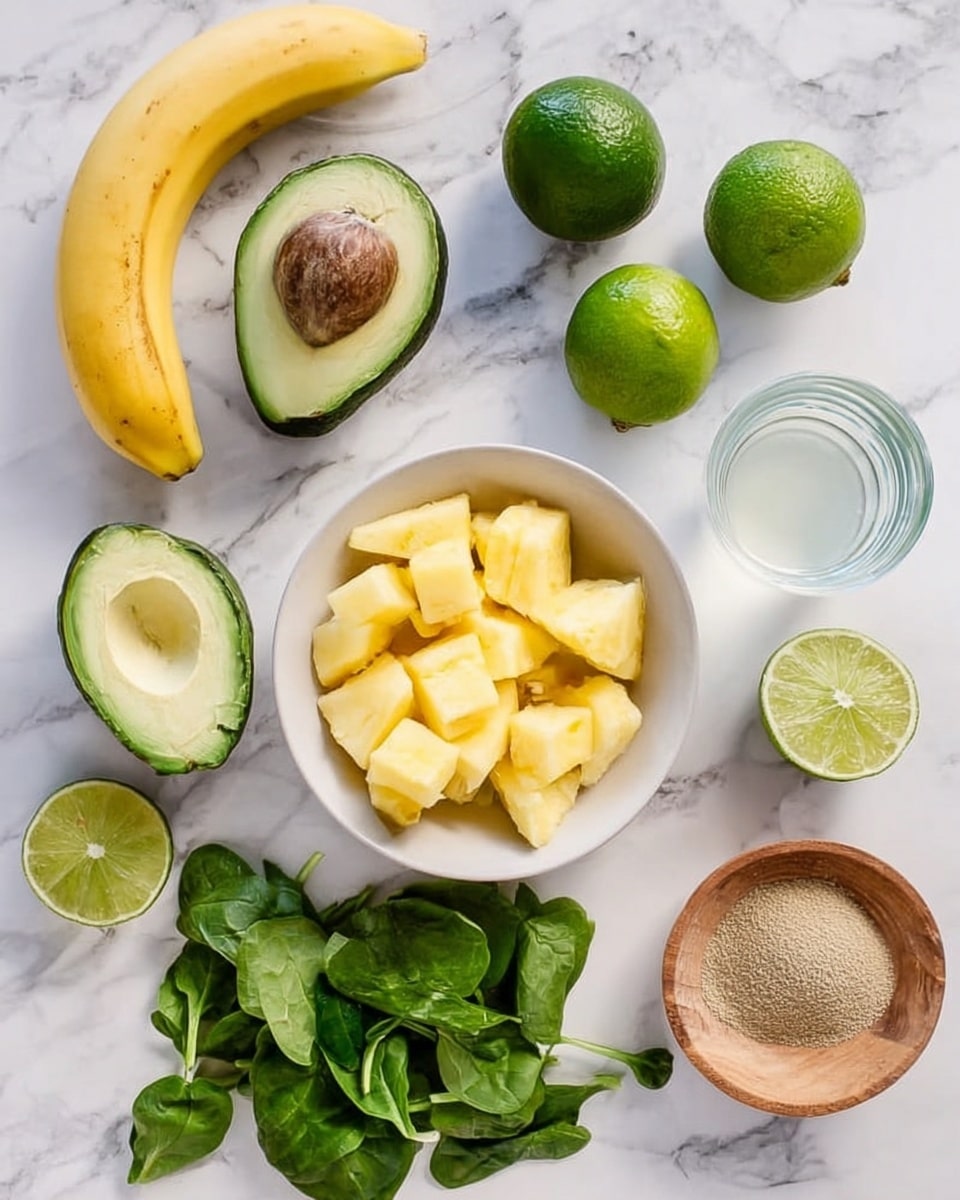 A white bowl filled with small chunks of yellow pineapple sits near the center of a white marbled surface. Surrounding it are various fresh ingredients: two halves of a green avocado with a brown pit in one half and the other half without, two whole bright green limes and two lime halves showing juicy light green insides, vibrant green spinach leaves scattered around in small bunches, a curved yellow banana, a small wooden bowl containing a coarse light brown powder, and two clear glasses with a milky white liquid inside. The scene is bright and fresh, all items laid out neatly on the white marbled surface. photo taken with an iphone --ar 4:5 --v 7
