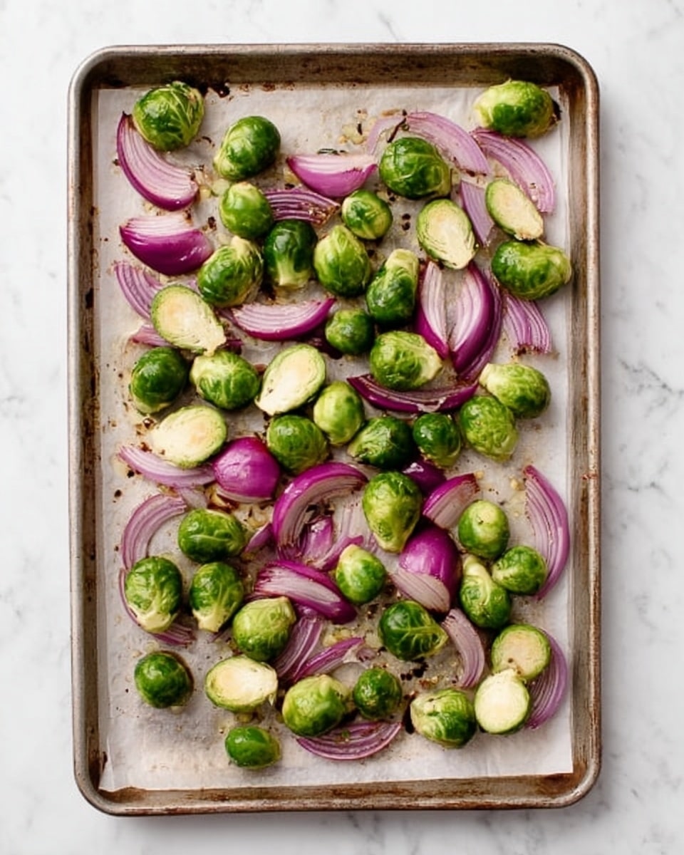 The image shows a baking tray filled with roasted Brussels sprouts. The Brussels sprouts are halved, with their cut sides golden brown and slightly crispy, showing a mix of light green and caramelized brown colors. Some outer leaves are a bit darker and charred, adding texture and variation. The baking tray sits on a white marbled surface. Photo taken with an iphone --ar 4:5 --v 7